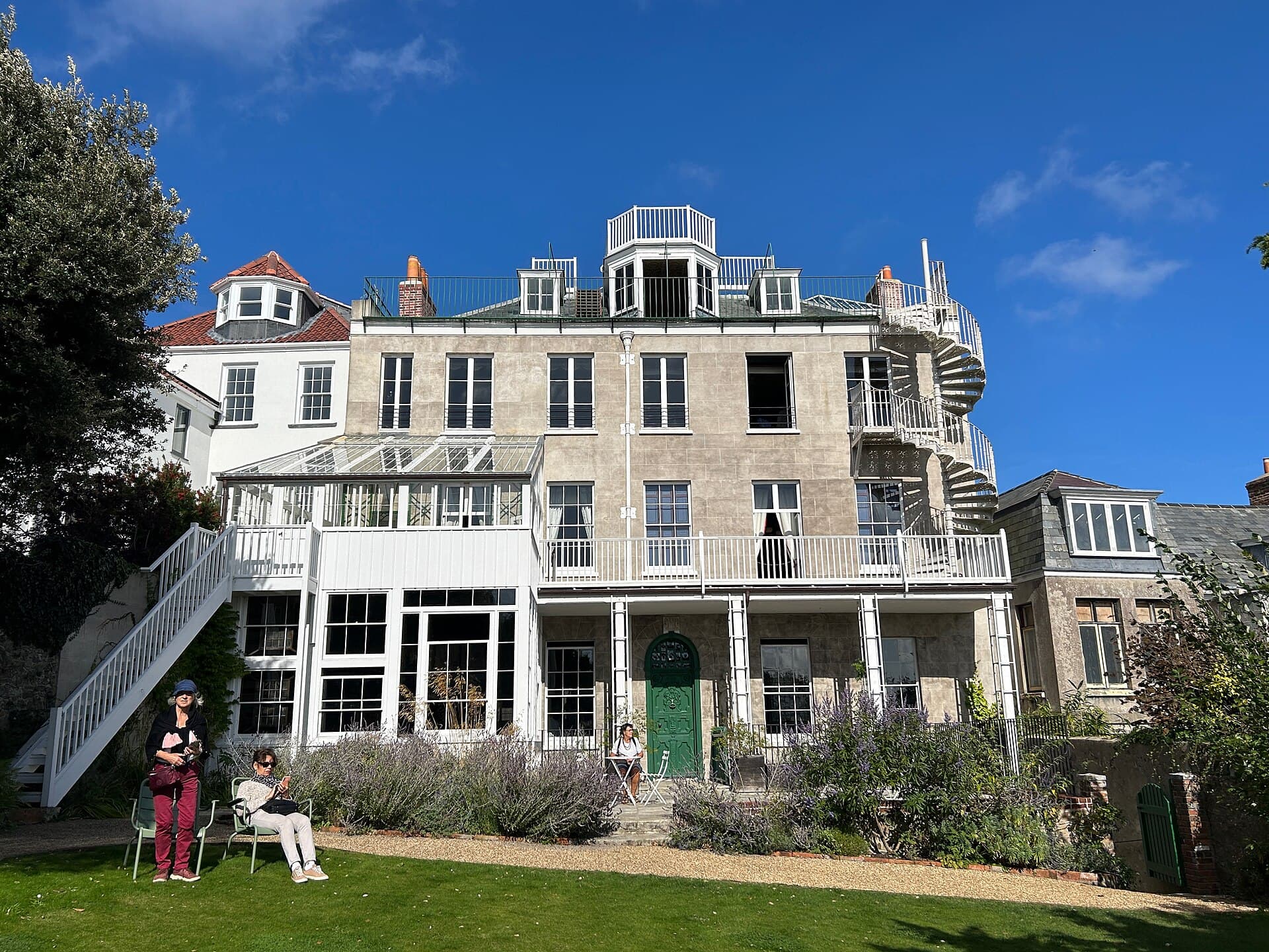 The garden front of Hauteville House in St Peter Port, Guernsey, with its conservatory, iron spiral stair and the glass lookout Victor Hugo built on the roof