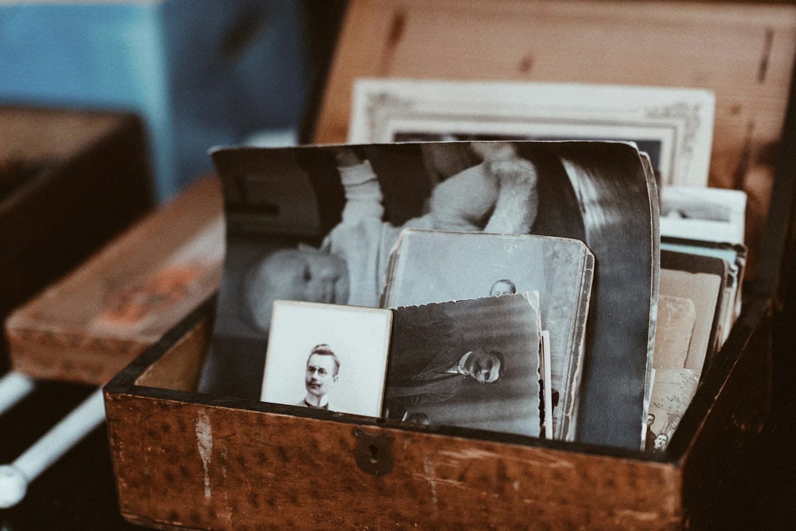Family photographs kept in a wooden chest — memories you can hold and return to.