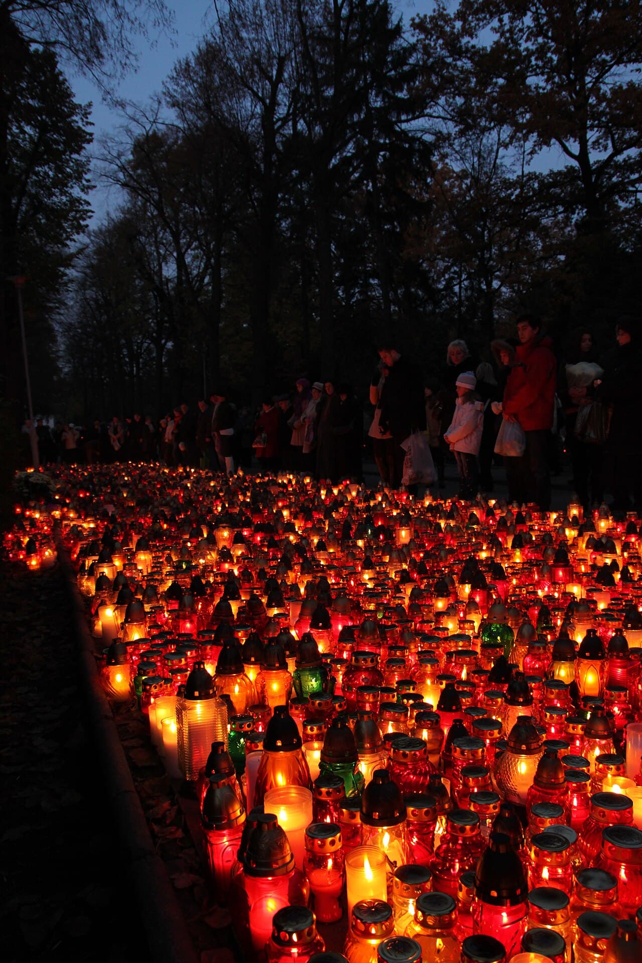 Graves lit with rows of candles for All Saints' Day at a Polish cemetery