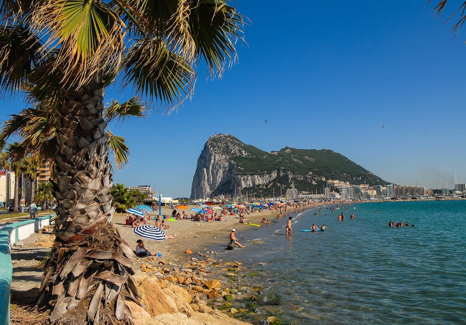 The Rock of Gibraltar rising above the shoreline, seen across the beach from La Línea de la Concepción in Spain