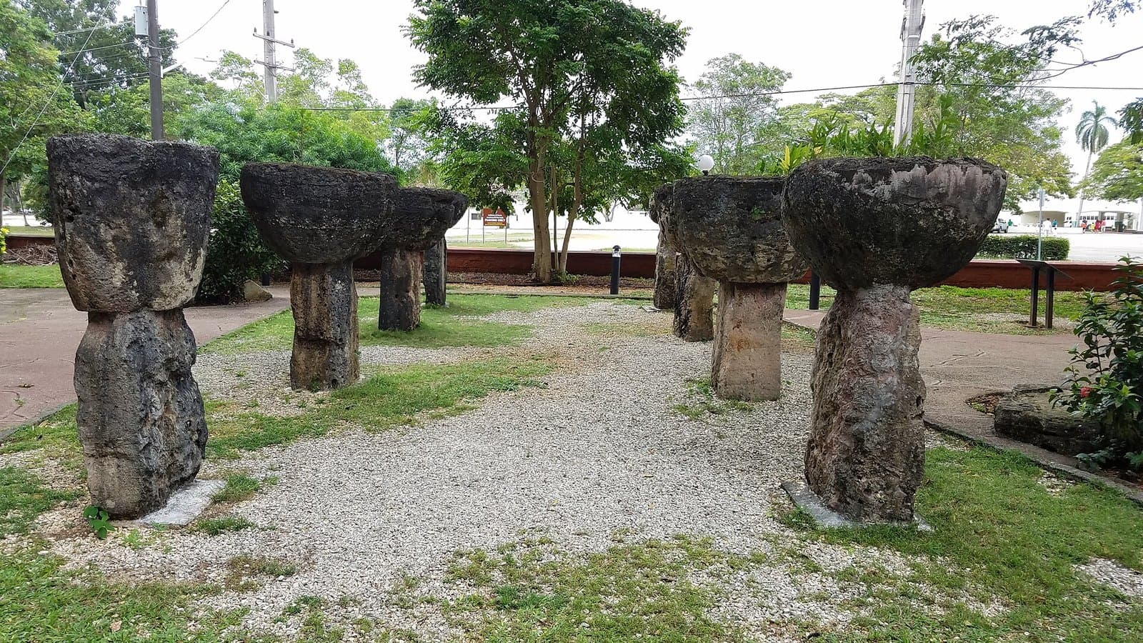Rows of latte stones, limestone pillars capped with cup-shaped tåsa, standing on gravel and grass at Latte Stone Park in Hagåtña, Guam