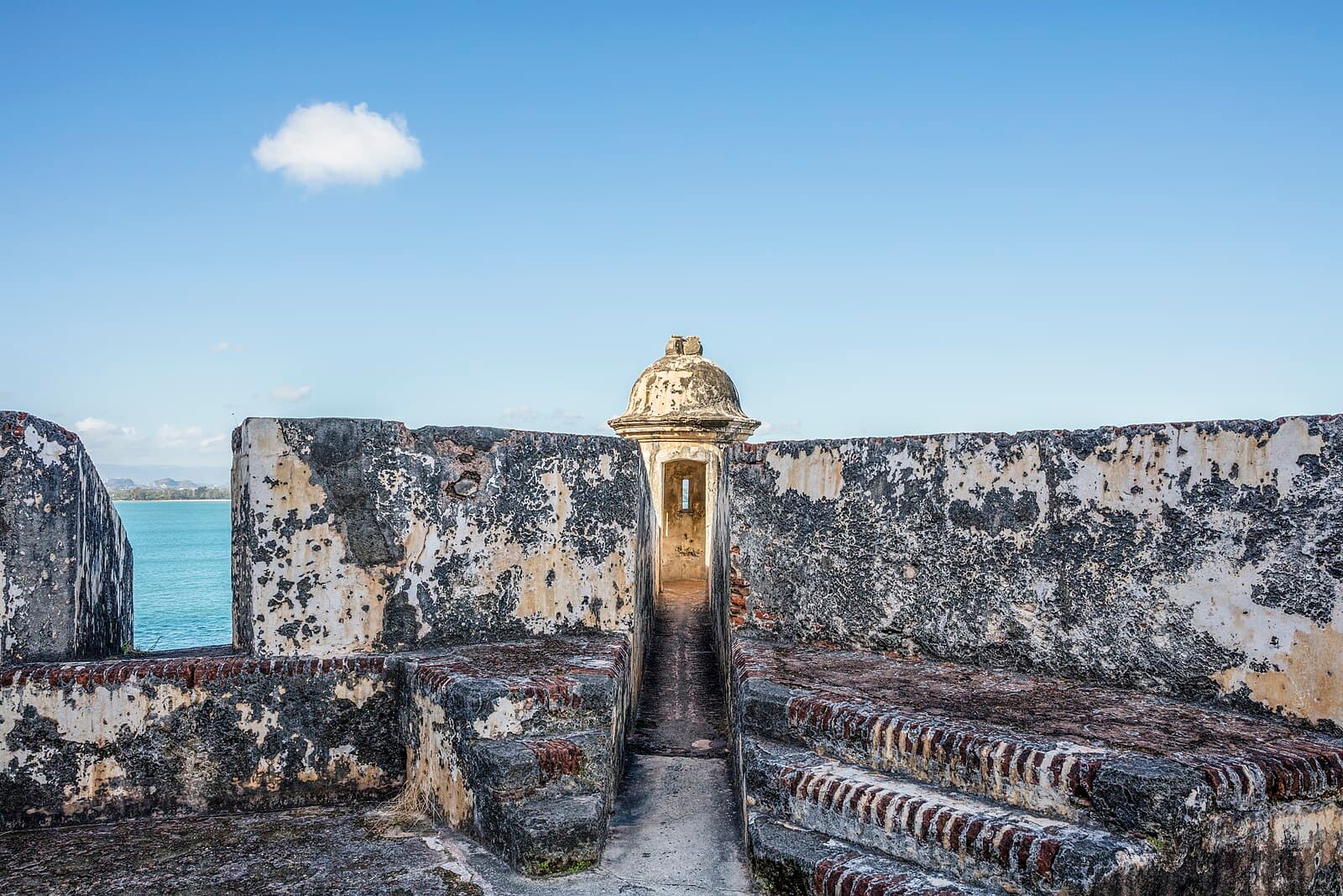 A stone sentry box, or garita, set into the weathered ramparts of Castillo San Felipe del Morro in San Juan, with the sea beyond