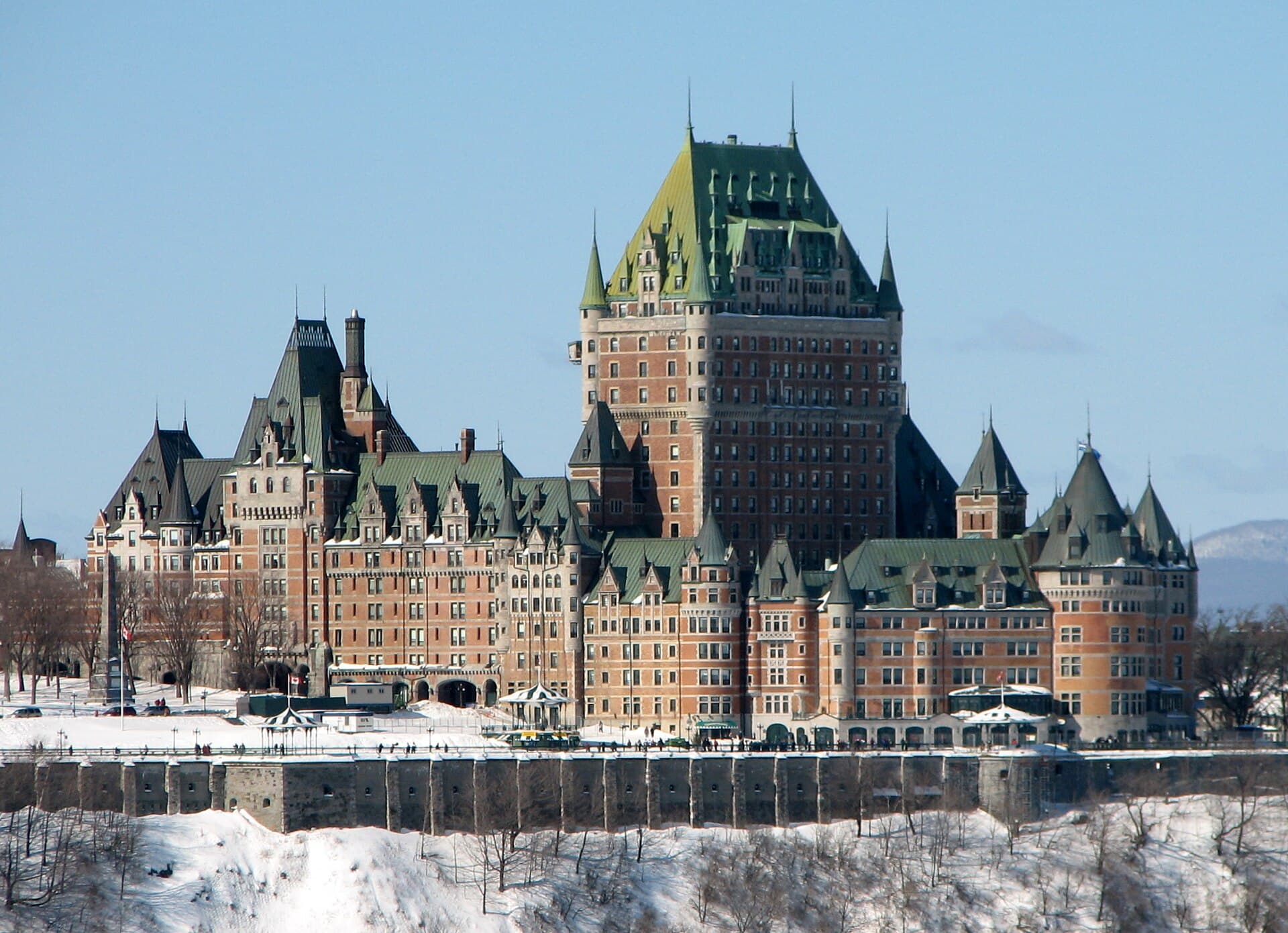 The Chateau Frontenac above the stone terrace wall of Old Quebec in winter, snow on the slope below