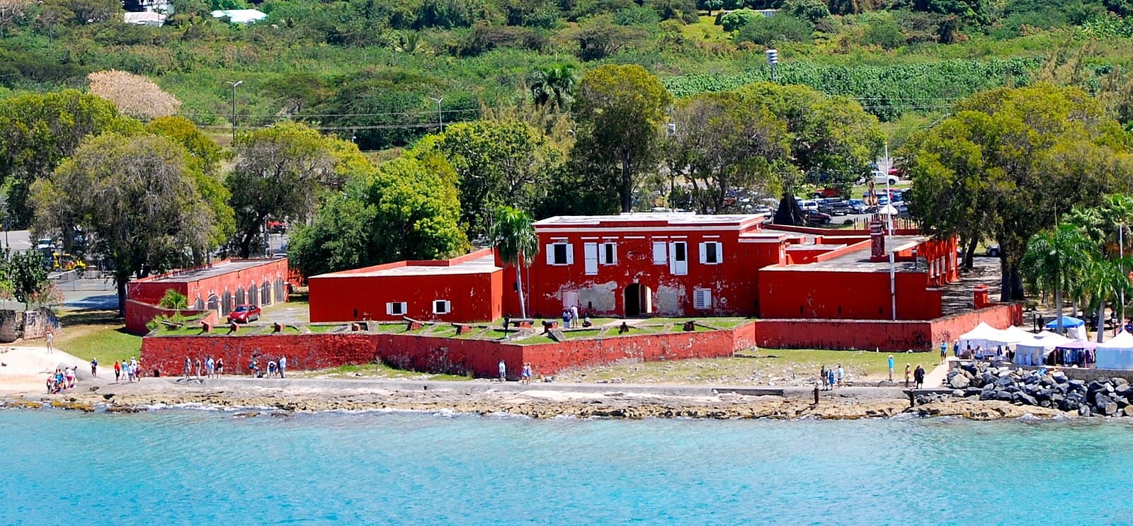 Fort Frederik, the red-walled Danish fort on the waterfront at Frederiksted, St Croix, with cannon on its ramparts and the sea in front