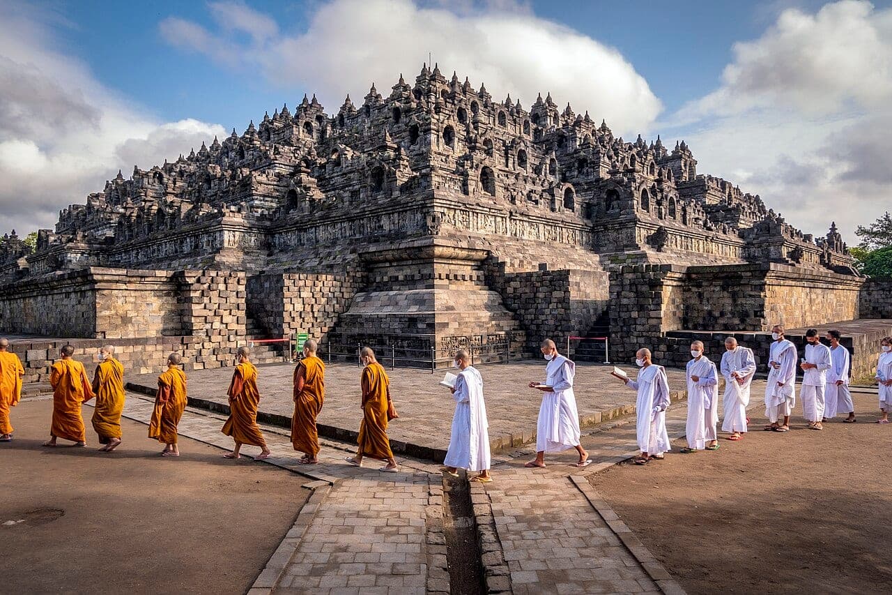 Pilgrims walking clockwise around the stone terraces of Borobudur temple in Central Java, Indonesia