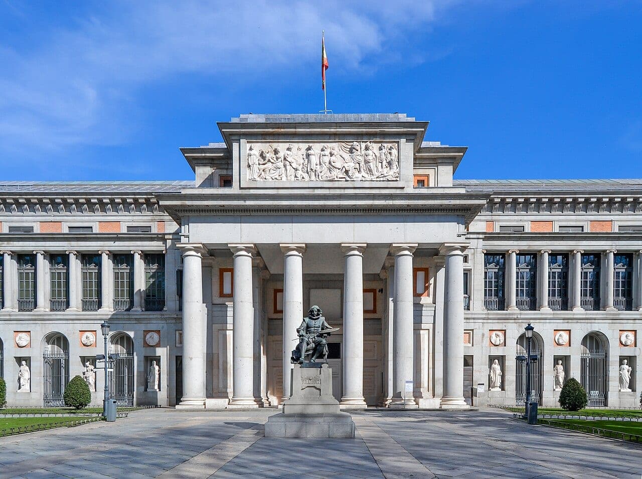 The neoclassical facade of the Museo del Prado in Madrid, with its columned entrance and pale stone architecture by Juan de Villanueva.