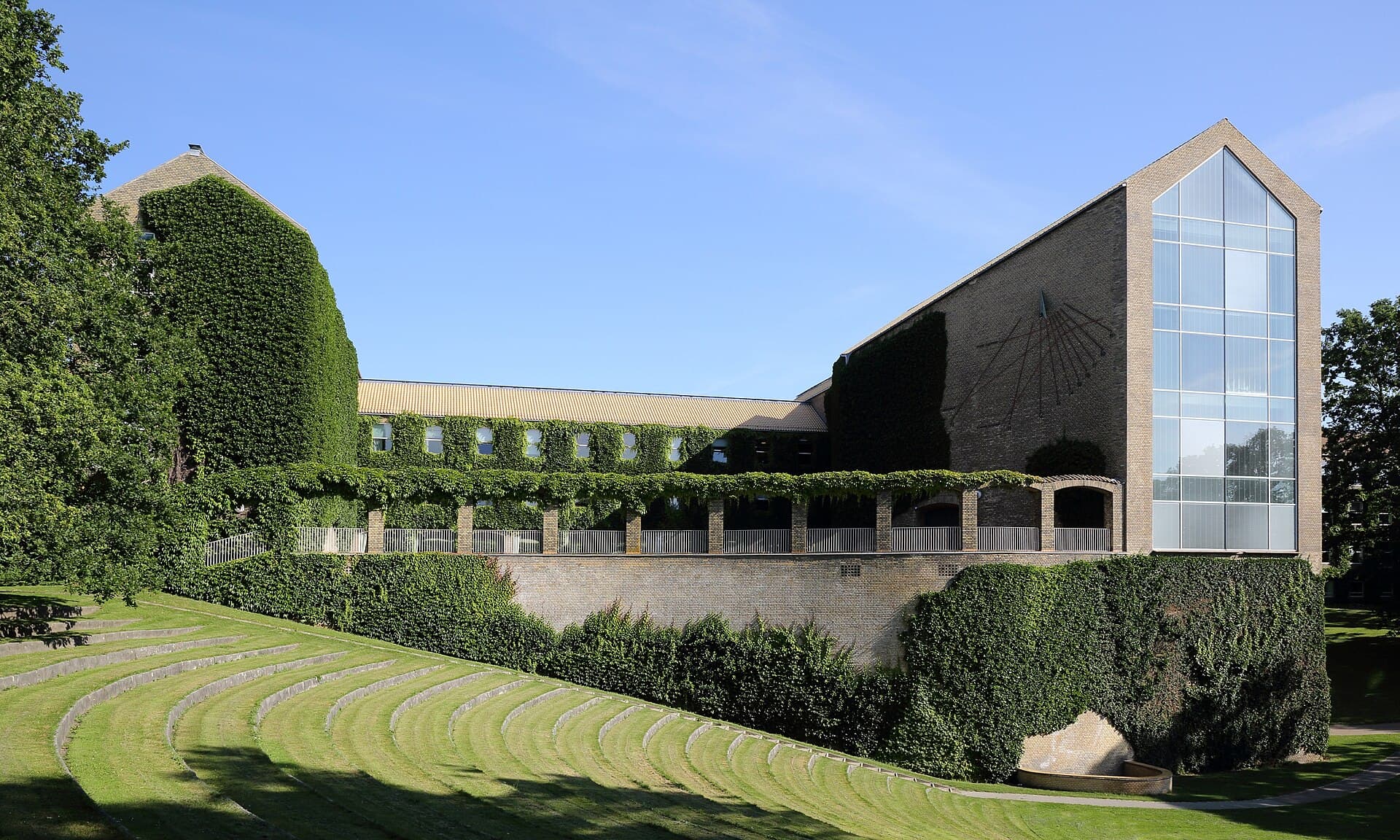 The yellow-brick main building of Aarhus University above the park amphitheatre